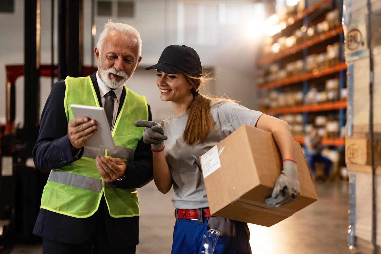 happy-mature-businessman-female-worker-using-digital-tablet-industrial-storage-compartment_637285-4196
