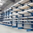 Blue steel cantilever racking system in a warehouse storing long metal and PVC pipes