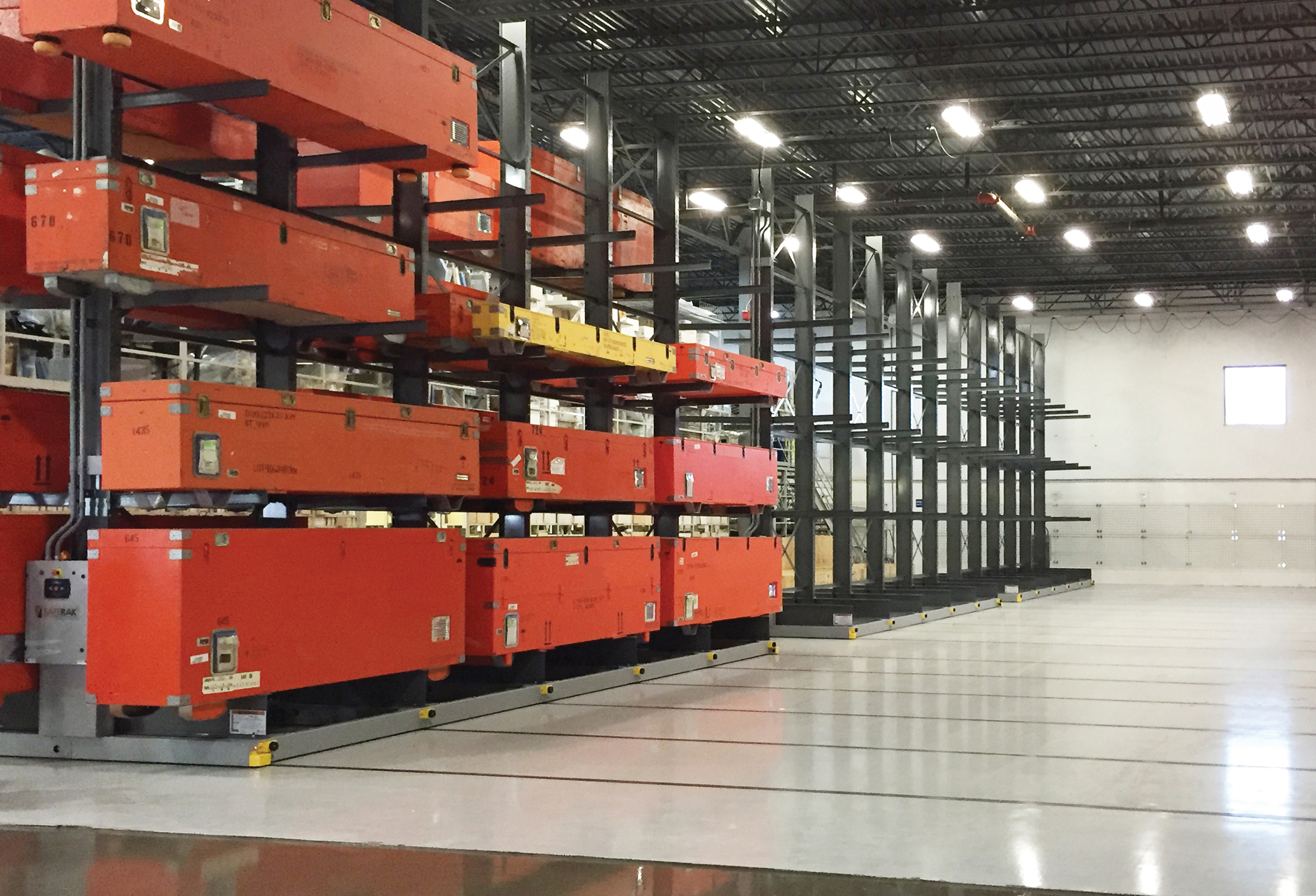 Wide view of industrial cantilever racking rows storing orange storage containers in a clean, modern warehouse