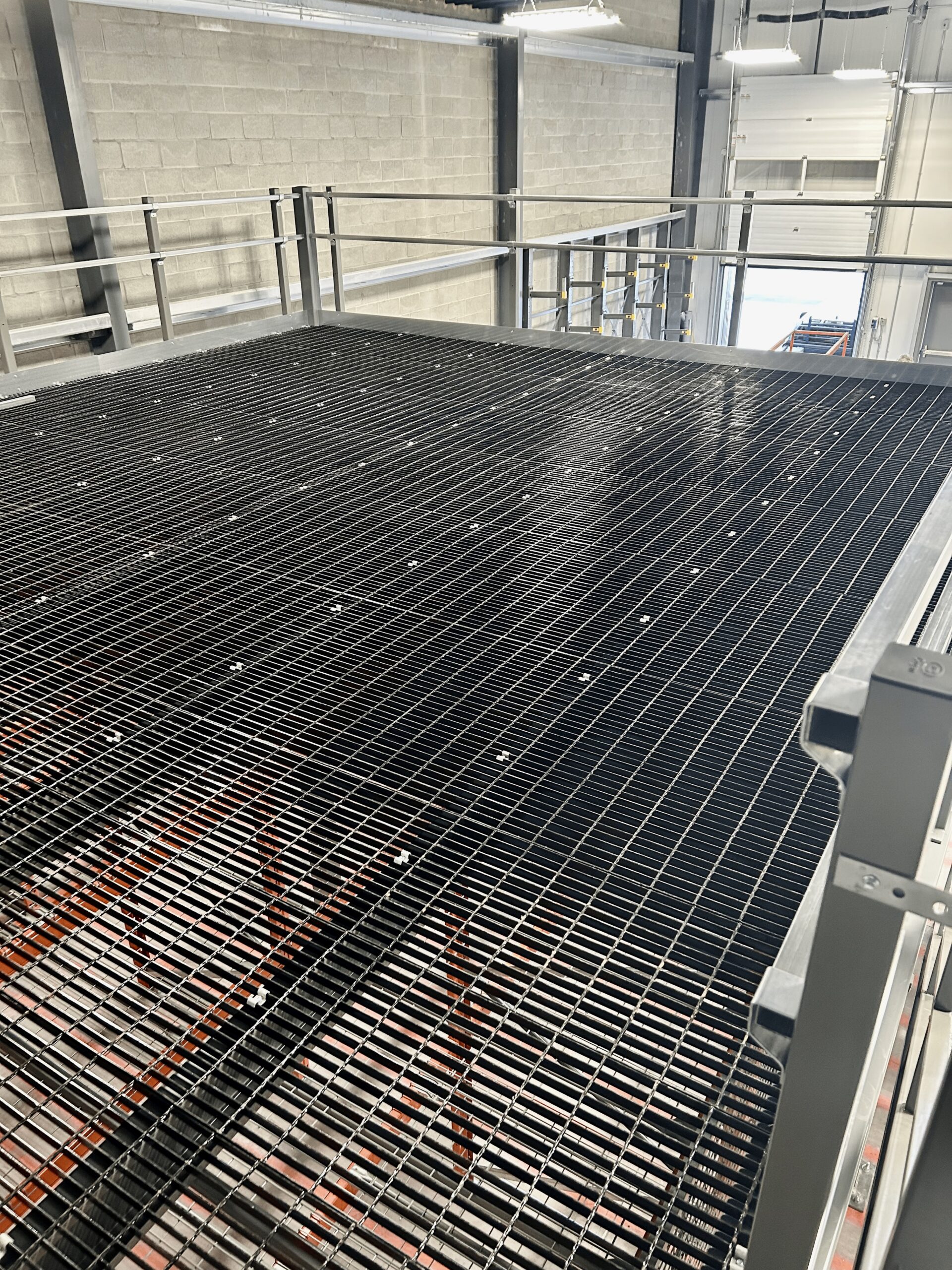 Bar grating floor on top of Cogan mezzanine installed by Pac Rac Systems